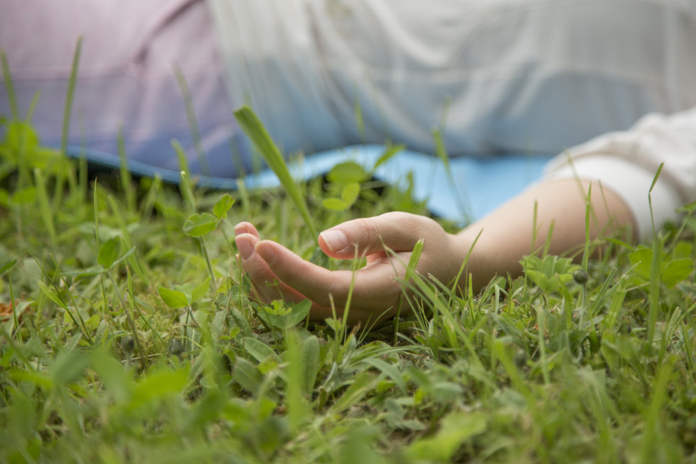 Savasana Stellung auf einer Wiese